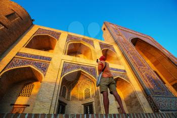 Tourist near ancient historic building in Uzbekistan