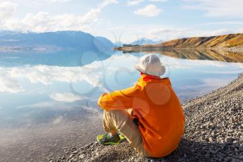 A man is sitting at ease by the calm lake. Relaxation vacation