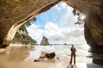 Couple of tourists in the Cathedral Cove, Coromandel Peninsula, New Zealand