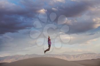 Jumping man above sand desert