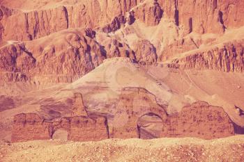 Unusual Egyptian landscapes. Dry mountains and anciend ruins toning in living coral color.