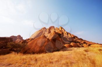 Colorful landscapes of the orange rocks in the  mountains in Namibia on a sunny hot day.