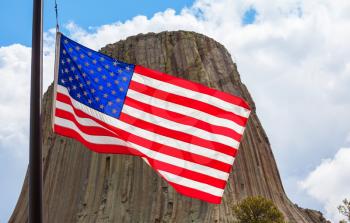 American flag on Devil's Tower National Monument background, U.S.A. 