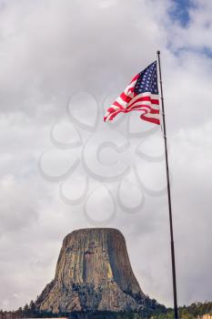 American flag on Devil's Tower National Monument background, U.S.A.