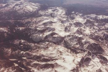 Aerial view from aircraft flying in mountains. Landscape from above.