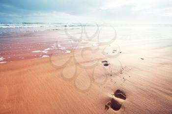 Beautiful ocean beach. Footprints on the sand.  Amazing holiday and travel background.