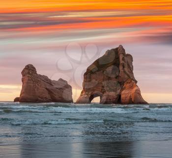 The Archway Islands of Wharariki Beach at sunset in New Zealand