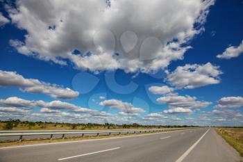 an asphalt road in the countryside against a background of clouds