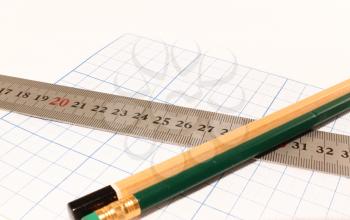 Drawing paper, pencil and ruler on a white background