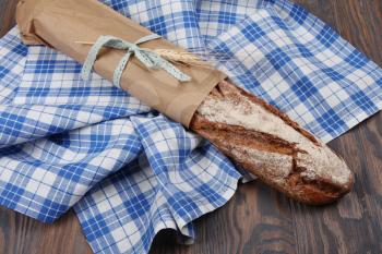 Homemade baked rye long loaf on blue towel
