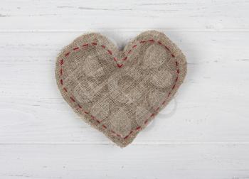 Sackcloth handmade heart on white wooden background