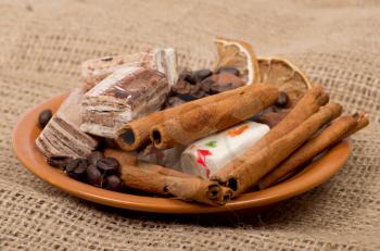 Royalty Free Photo of a Plate of Cinnamon Sticks and Nougats