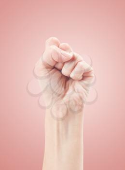 Fist. Gesture of the hand on pink background.
