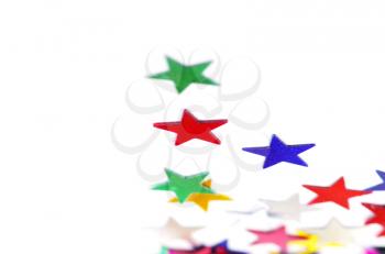 Christmas decoration of colored confetti stars against white background