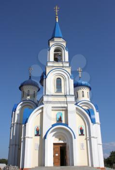 Christian church with dark blue domes of white color against the dark blue sky
