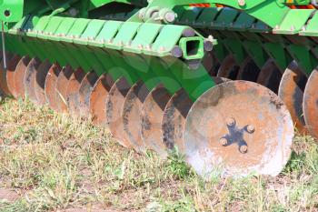 disc harrow behind tractor turning the soil 