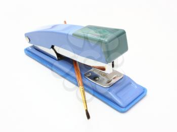 Stapler of dark blue color and brush for paints on a white background