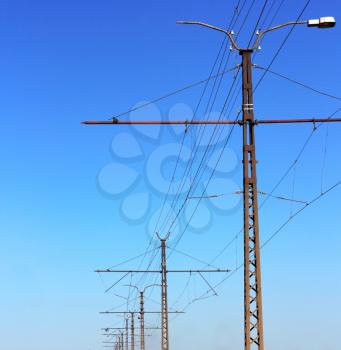 Railroad railway catenary lines against clear blue sky. 