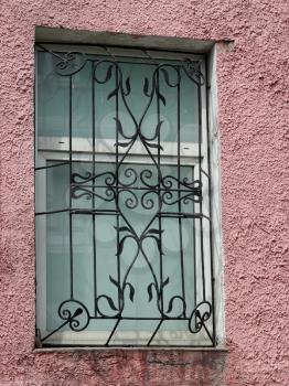 black metal forged carved lattice at a white window