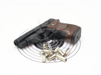 The pistol with the brown handle with a target and cartridges lies on a white background