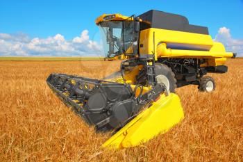 combine harvester on a wheat field with a blue sky