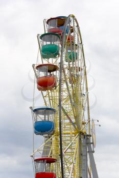 Brightly colored Ferris wheel against a background of clouds