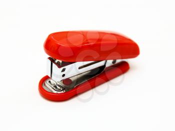 The red stapler lies on a white background