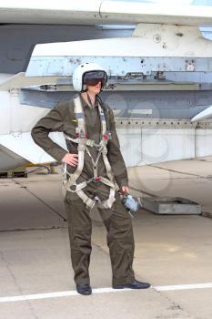 military pilot in a helmet near the aircraft