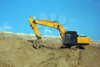 Yellow excavator, excavation work at a construction site.
