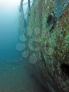 massive shipwreck, sits on a sandy seafloor in bali                