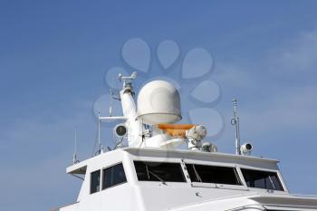 Ships antenna and navigation system in a clear blue sky.