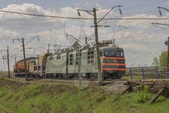 Green freight train transports cargo by rail.