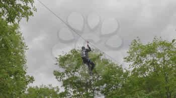 MOSCOW - JUNE 4: Man descends on a bungee between the trees on June 4, 2017 in Moscow, Russia. UltraHD stock footage.