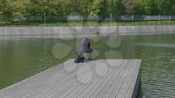 Fisherman catches fish in the lake with a fishing rod