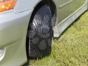 Close up car tire on the green grass.