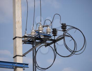 Electric transformer with wires and an insulator against the sky.