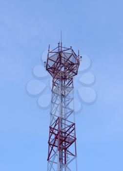Telecommunication tower with antennas against with blue skyand white cloud background