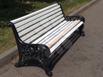 White wooden bench in the park on the street