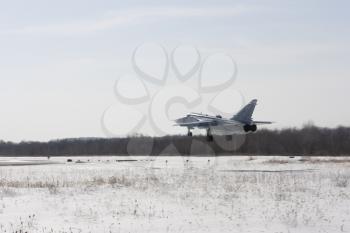 Military jet bomber Su-24 Fencer flying above ground.