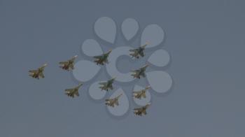 Fighters Su-35 and MiG-29 lined diamond fly with fireworks fly in sky on training parade in honor of Great Patriotic War victory.