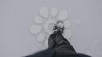Top view of a man walking in the snow in winter.