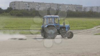 Wheeled tractor blue dub track racecourse old car tires.