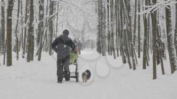 MOSCOW - JANUARY 17: winter walk father with a baby in a stroller with a dog on January 17, 2018 in Moscow, Russia.