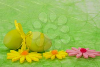 Easter background. Easter eggs and flowers on green sisal background, selective DOF.