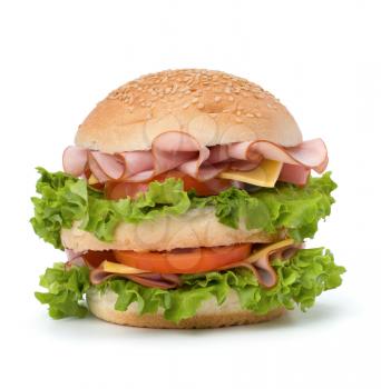 Big appetizing fast food sandwich with lettuce, tomato, smoked ham and cheese isolated on white background. Junk food hamburger.