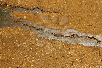 Close-Up of Rural Road Surface Cracks and Breaking Up