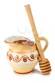 honey in a jug and wooden stick isolated on white background