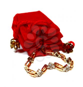 red sac for a gift and gold bangle with stones isolated on white background