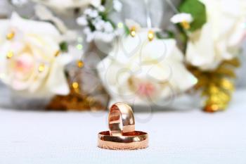 two couple gold wedding rings and rose