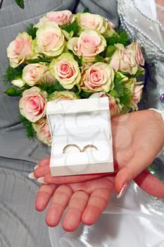 two wedding rings in white box and bouquet for fiance and fiancee